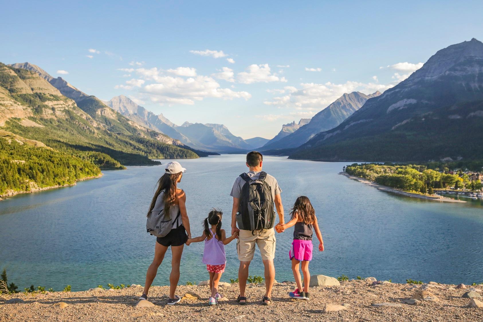 family overlooking a lake in the mountains