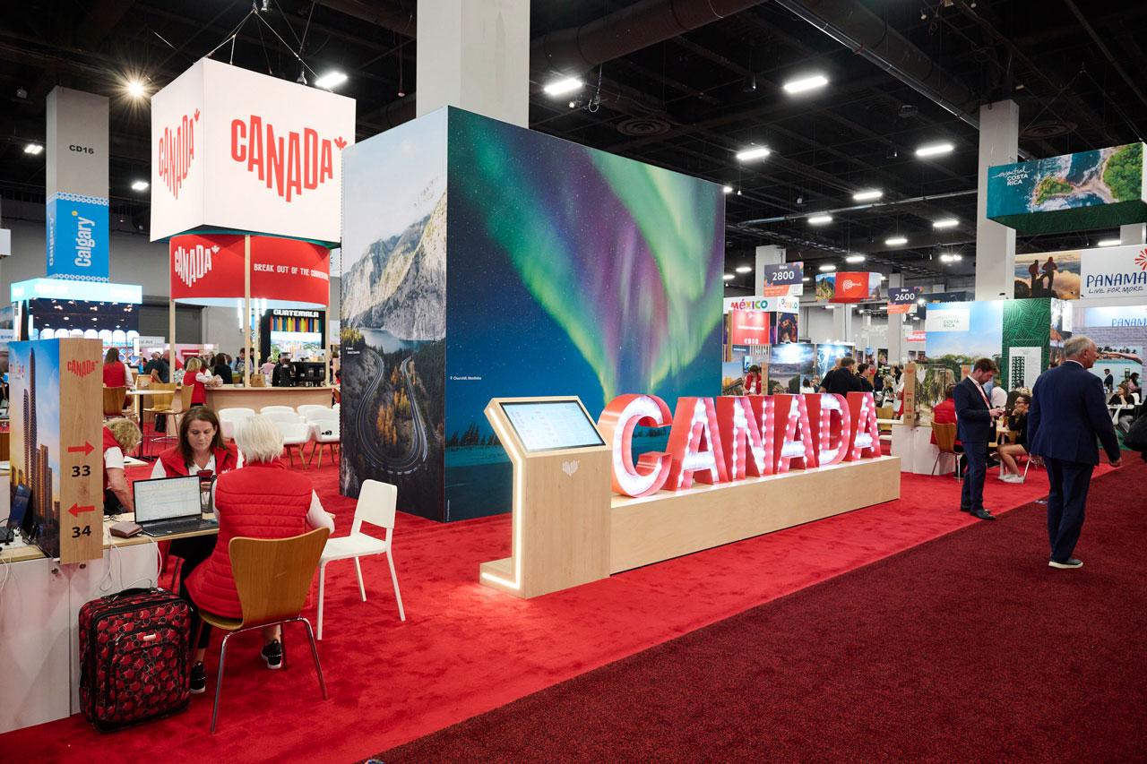 A lit-up Canada sign and large aurora backdrop at a tradeshow