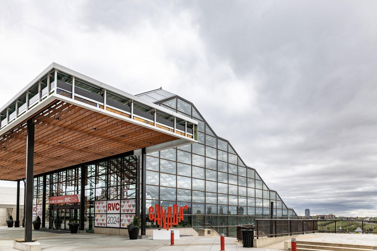 Glass-enclosed building with a modern design, featuring a "Canada" sign at the entrance