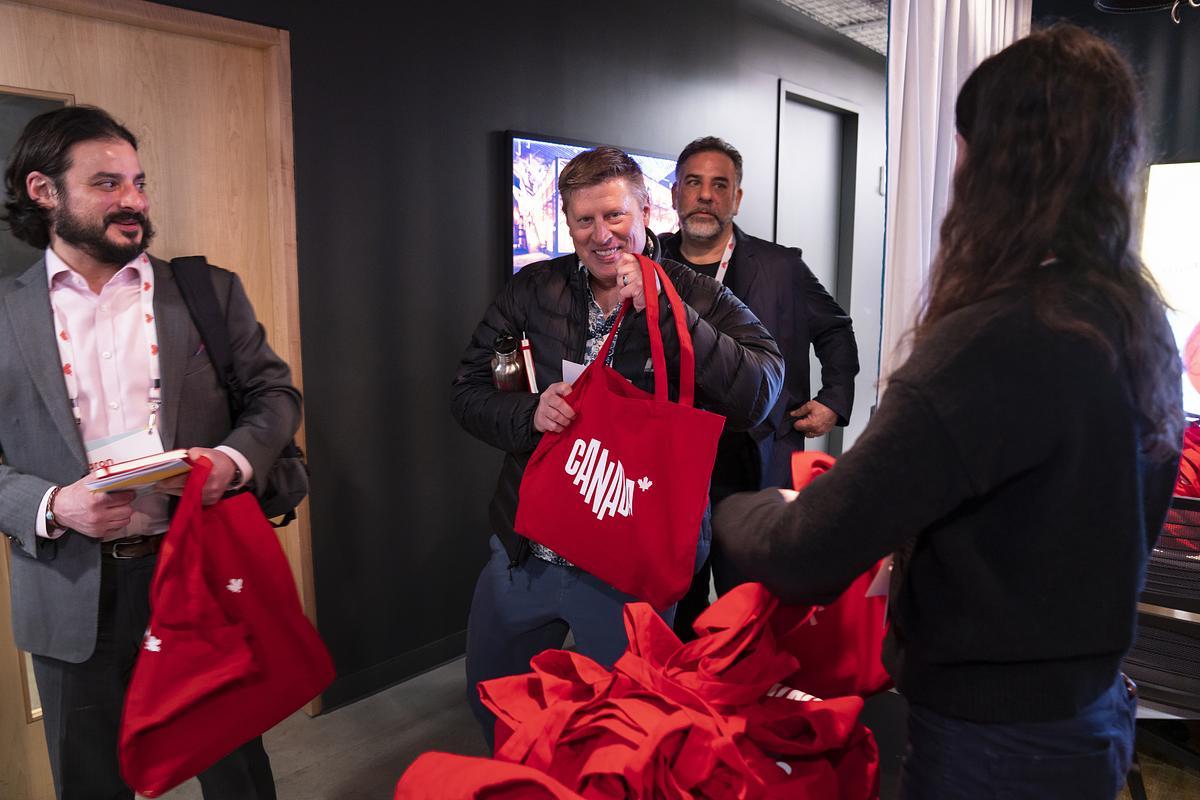 A person holding up a Destination Canada branded tote bag
